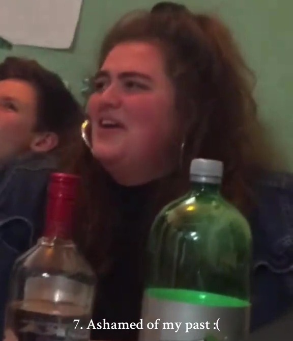 A woman sits at a table with drinks, expressing shame about her past.