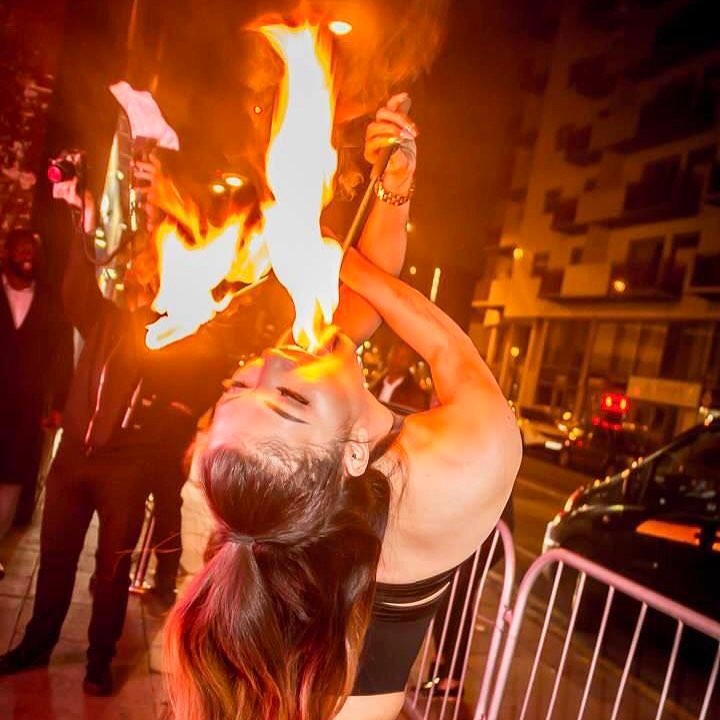 Woman fire breathing at night.