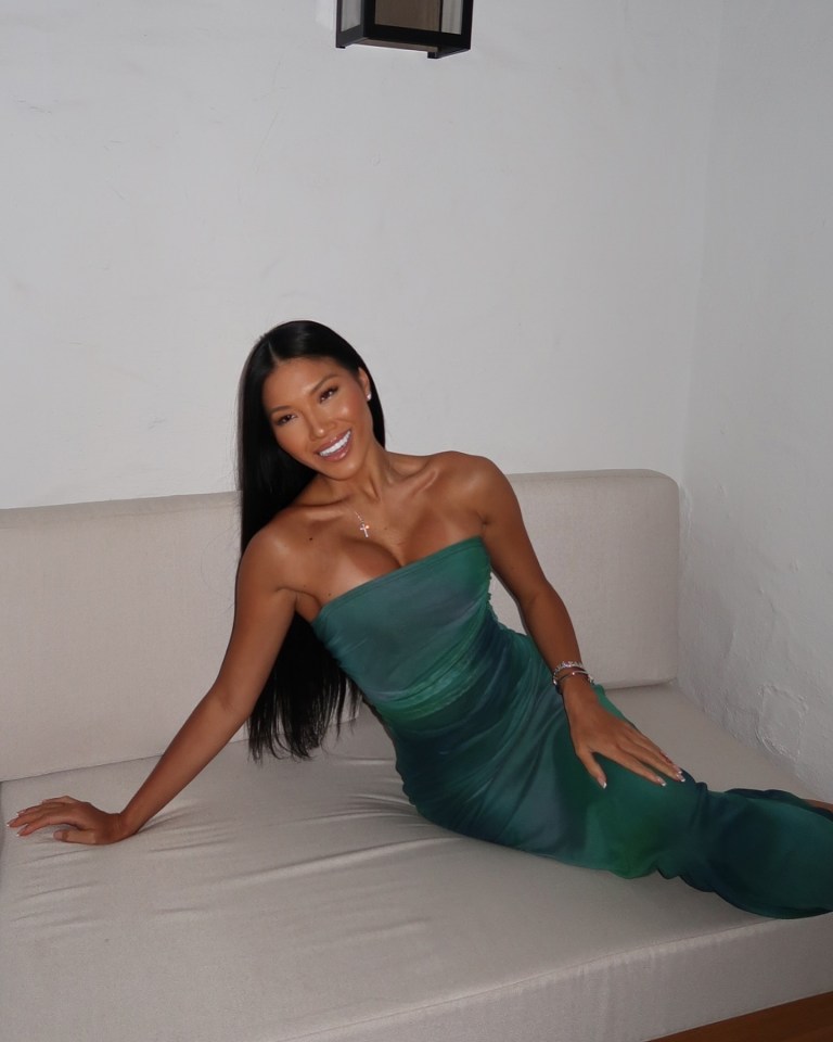 Woman in green dress sitting on a couch.