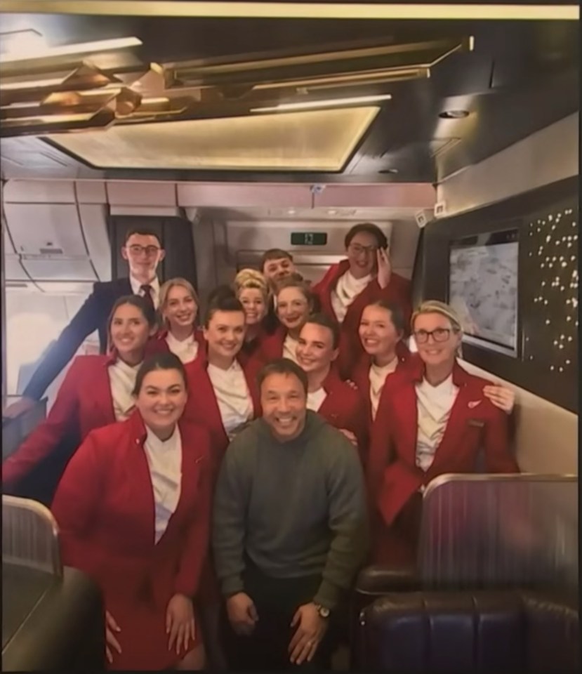 Stephen Graham with flight attendants on a plane.