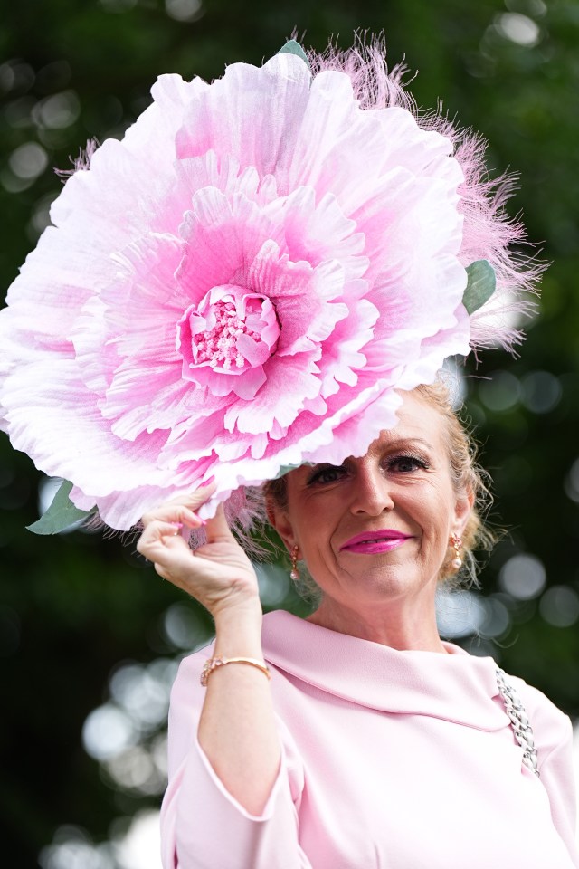 Woman wearing a large pink flower hat.