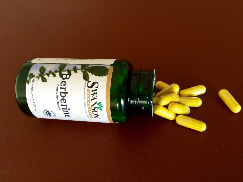 Berberine dietary supplement capsules spilling from bottle.