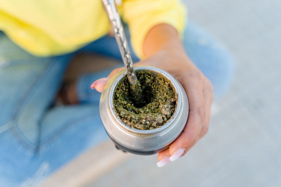 Close-up of a person preparing mate tea.