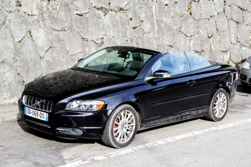 Black Volvo C70 convertible parked in a parking space.