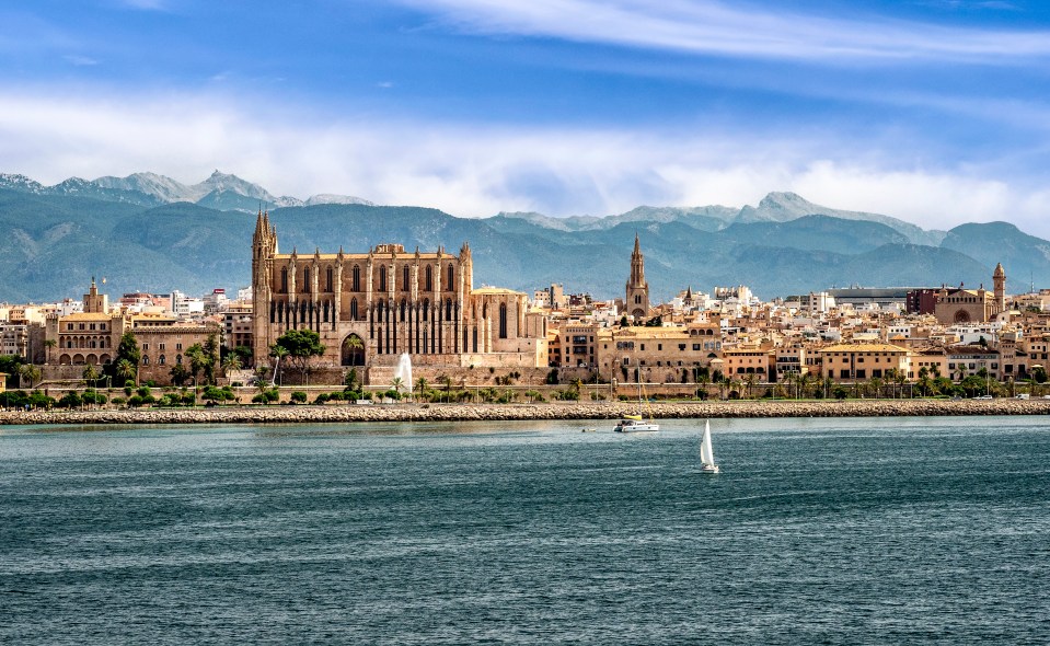 Palma de Mallorca cityscape with cathedral and mountains in the background.