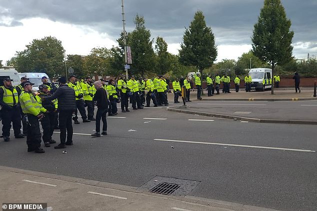Leicestershire Police officers block a road to control people gathering in the city