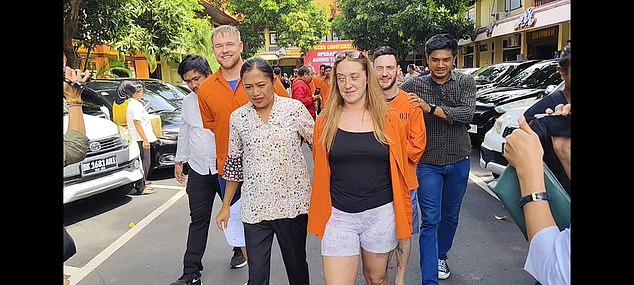 The trio, in regulation orange tops, pictured being paraded in front of local media during a press conference last week