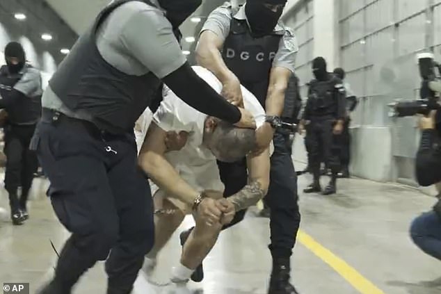 In this undated photo provided by the U.S. District Court for the District of Maryland, a man identified by Jennifer Vasquez Sura as her husband, Kilmar Abrego Garcia, is led by force by guards through the Terrorism Confinement Center in Tecoluca, El Salvador