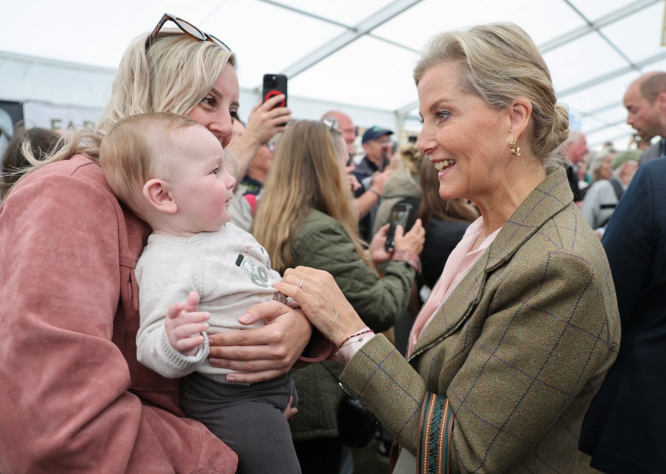 Sophie, Duchess of Edinburgh, speaks with a mother and baby.