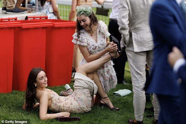 Heel-ing hands: A racegoer pulls a sultry pose as she rests on the lawns next to the track