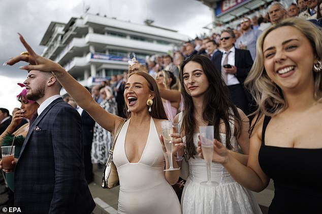Waiting for the mane event: These ladies are all smiles as they watch the horse racing