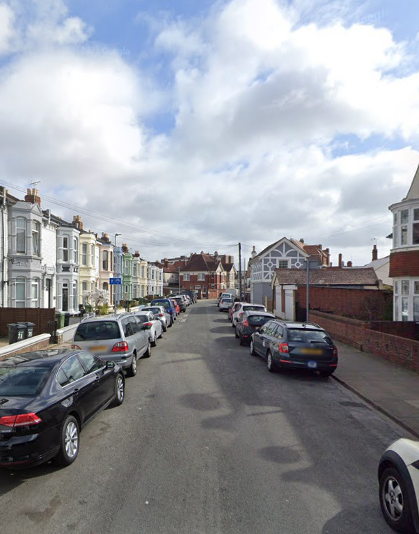 Residential street with parked cars.