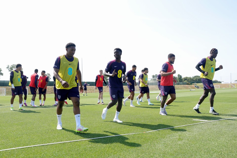 England soccer players warming up on a field.