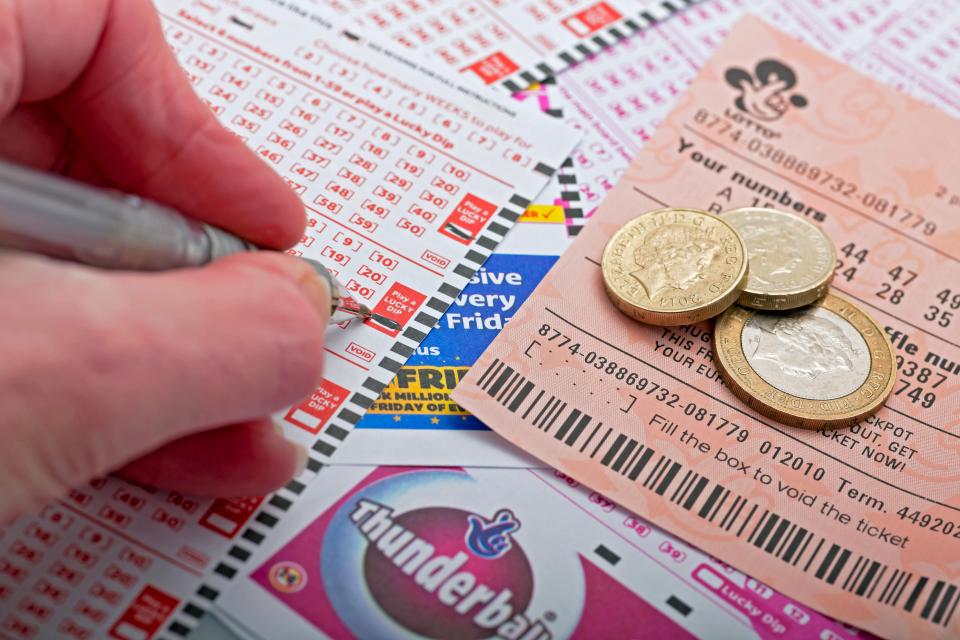 Person filling out a National Lottery ticket.