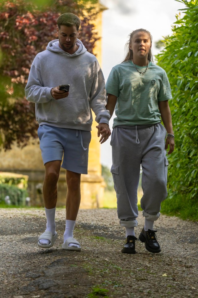 JoJo Siwa and Chris Hughes holding hands and walking.