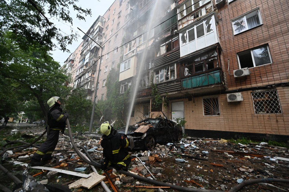 Firefighters extinguishing a fire at a damaged residential building in Kharkiv, Ukraine.