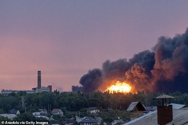 Fire is seen among the smoke clouds billowing from a Russian attack on Kharkiv