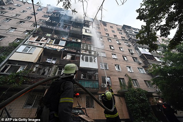 Firefighters extinguish a fire at a multi-storey residential building following powerful attacks to Ukrainian city of Kharkiv