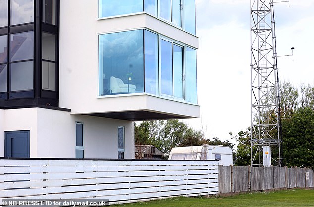 Locals suggested the house may fail to meet building regulations because external glass doors on two floors are without balconies (pictured)