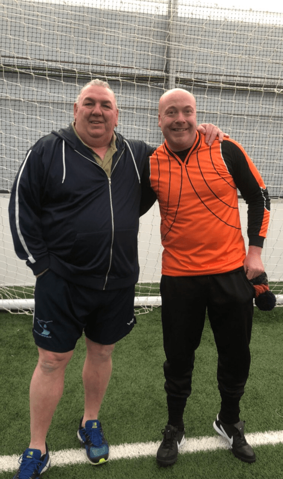 Two men standing on a soccer field.