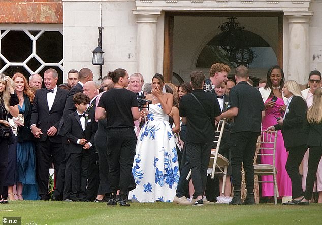 The newlyweds joined their guests outside as a photographer organised a group shot