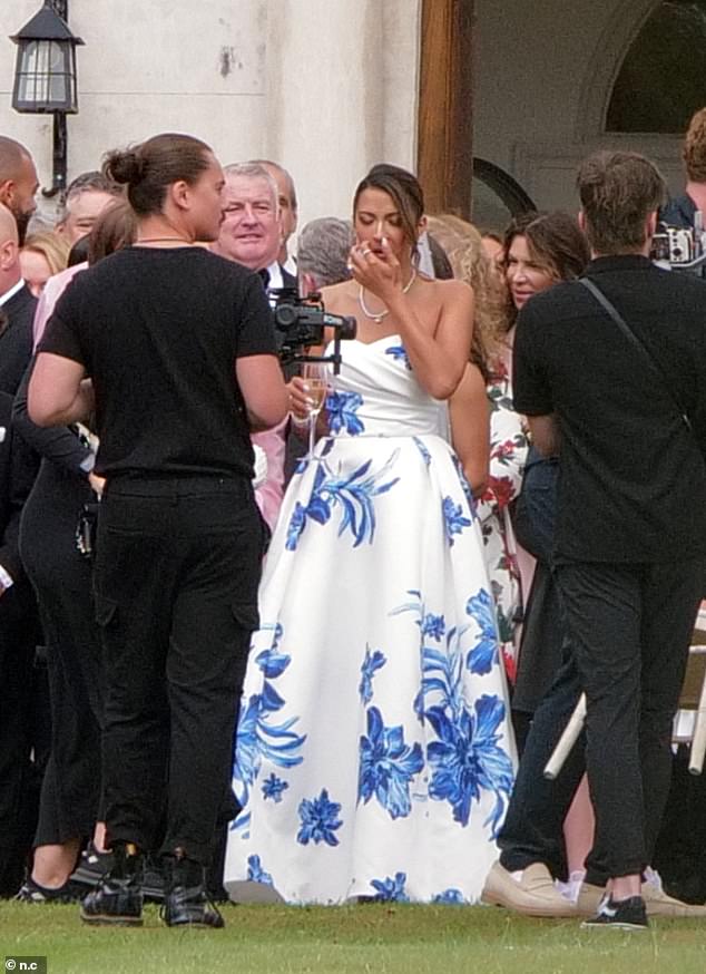 The happy couple looked in good spirits as they sipped champagne while joining their guests outside the idyllic country house for group photos