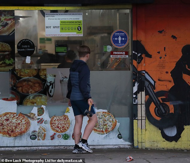 One boy wielded a lump hammer, smashing it against the shutters of a local corner shop - before turning his attention to a nearby bin