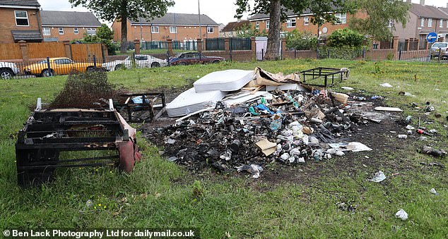 Mattresses, broken chairs and other fly-tipping last abandoned in the middle of a field