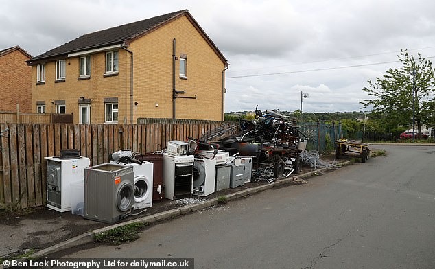 Washing machines and other electronics are dumped on the side of a road