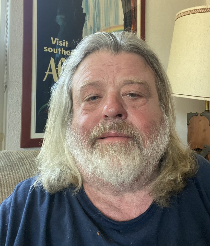 Portrait of a man with long gray hair and a gray beard.