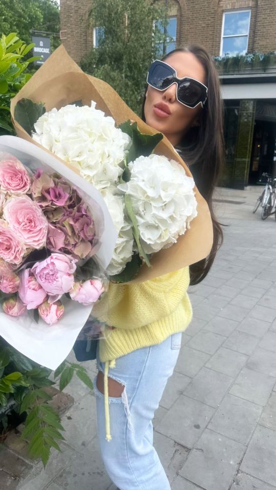 Woman holding a large bouquet of flowers.