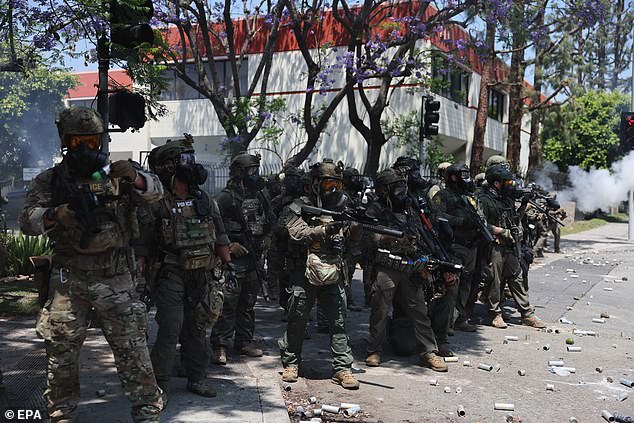 Federal agents hold a line during a clash with protesters near a Home Depot after a raid was conducted by Immigration and Customs Enforcement (ICE) in Paramount, California on Saturday