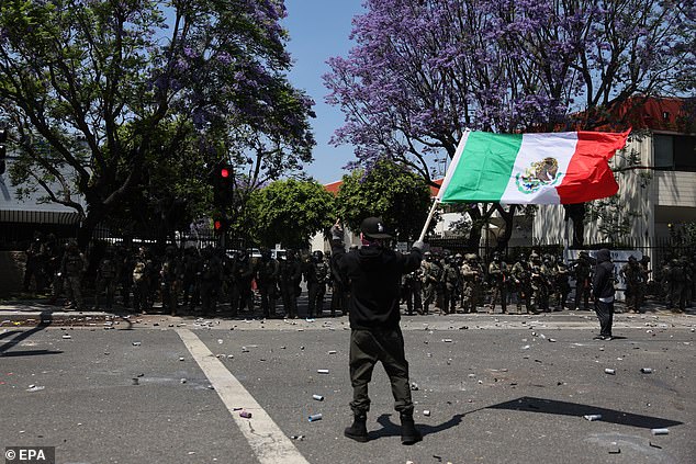 A protester holds a Mexican flag during a clash with federal agents near a Home Depot