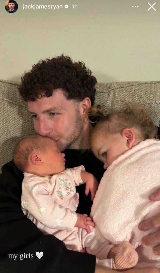 A man cuddling his two daughters.