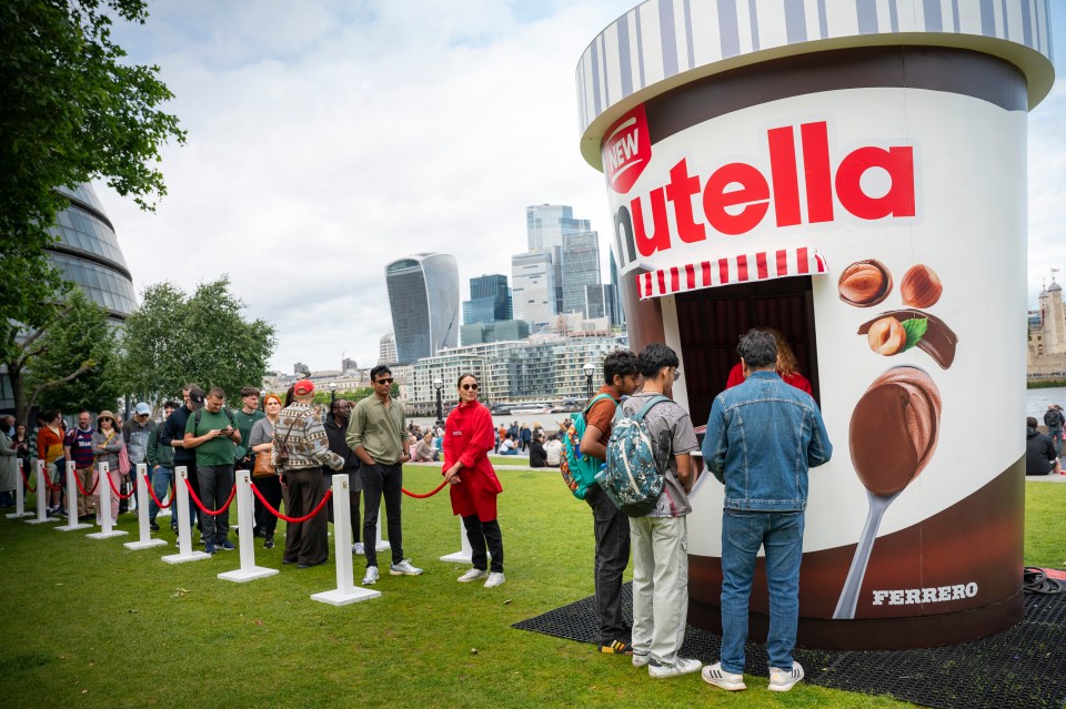 People lining up at a giant Nutella ice cream tub pop-up shop.