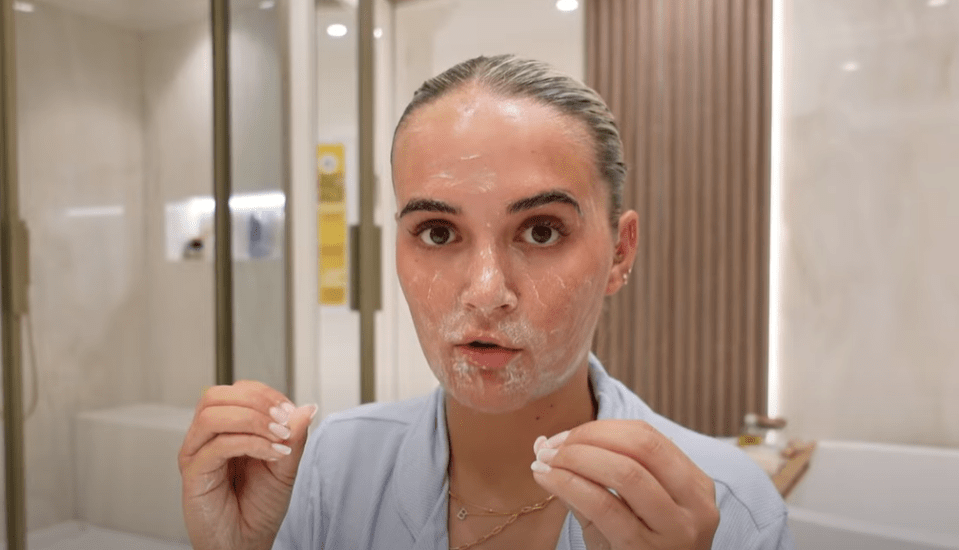 Woman applying face cleanser.