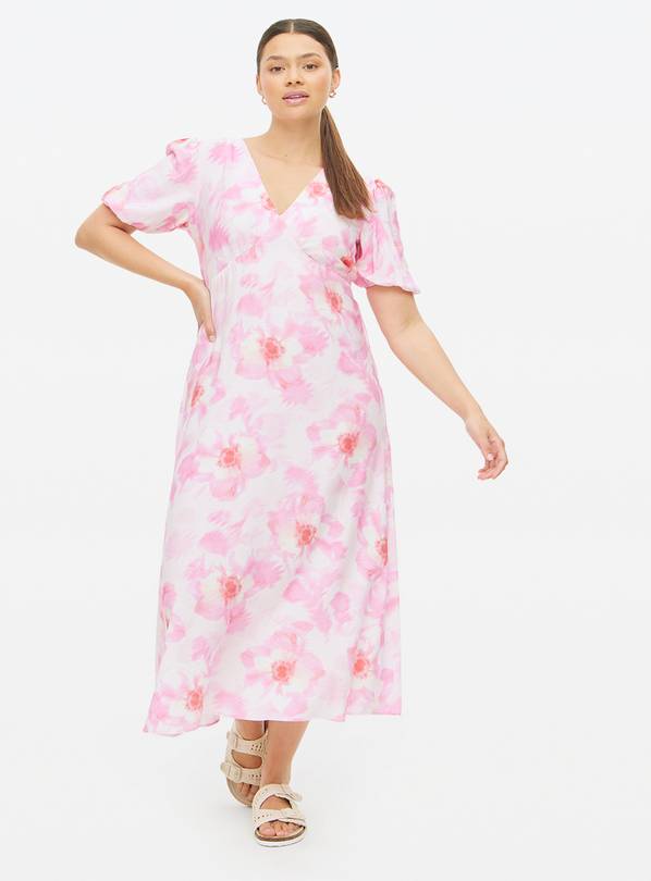 Woman wearing a pink floral midi dress.