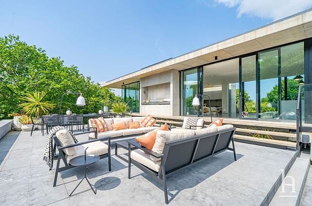The stunning house features large entertaining terraces, full width balconies, an outdoor kitchen and heated swimming pool
