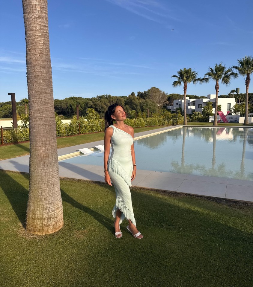 Woman in light green dress by a pool.