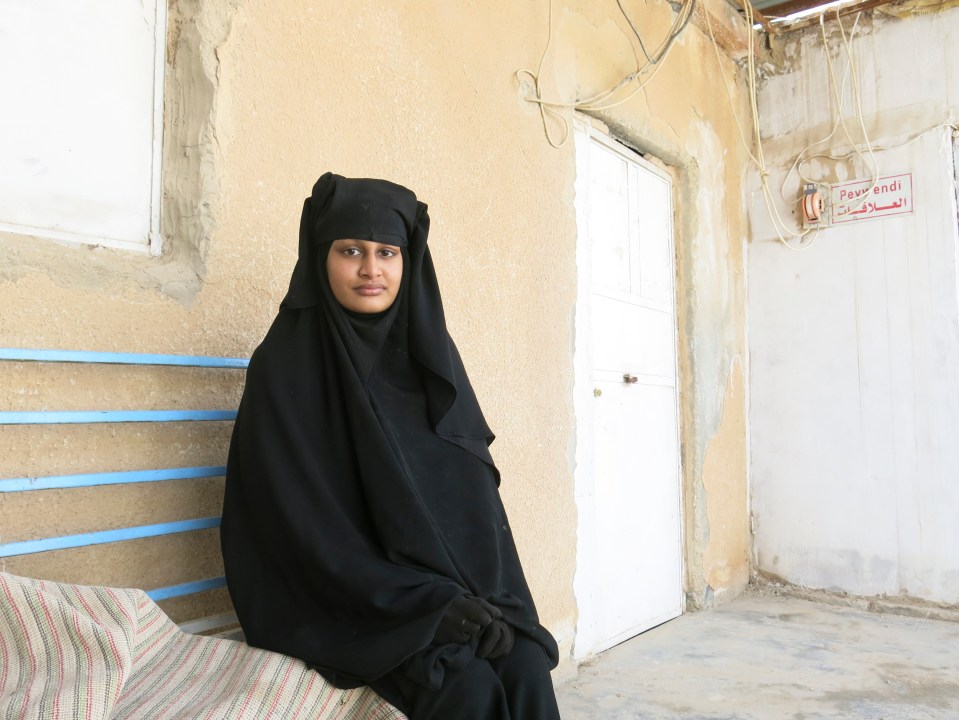 Shamima Begum, a young woman wearing a niqab, sits on a bench.
