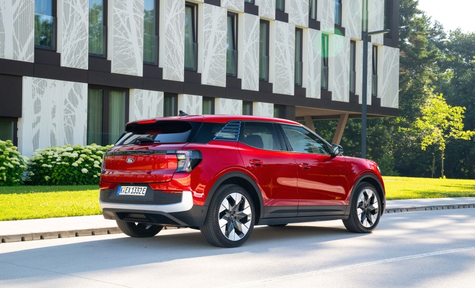 Rear view of a red Ford Explorer parked on a city street.