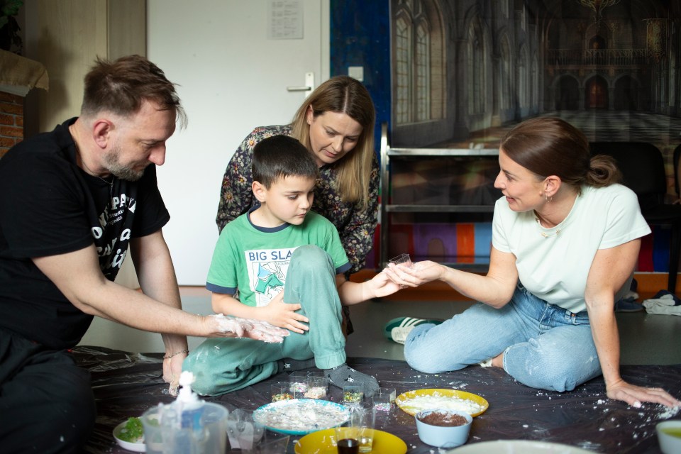 Coleen Rooney and others participate in a sensory therapy class with a child.