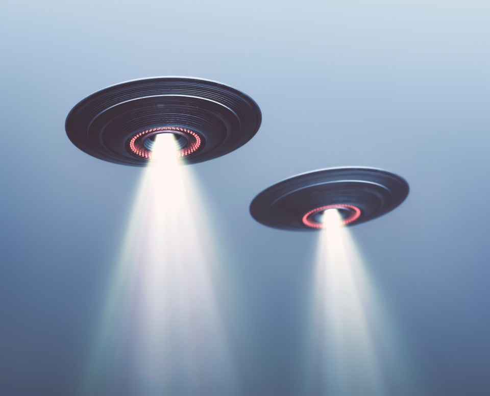 Illustration of two UFOs flying in foggy sky.