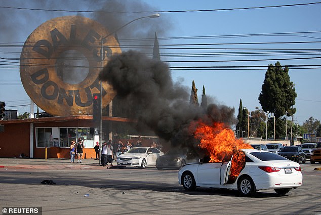 A car burns in flames following multiple detentions by ICE in the Los Angeles County city of Compton