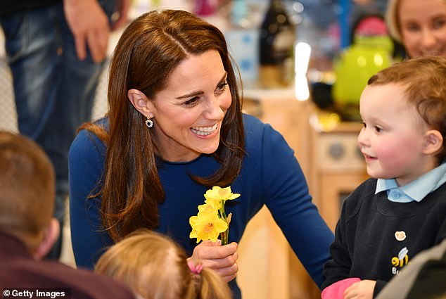 Kate is pictured chatting with a child during a visit to Northern Ireland