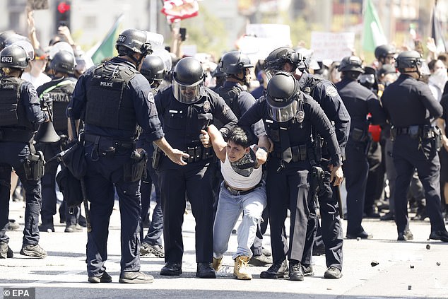 A protester is arrested during the wild scenes
