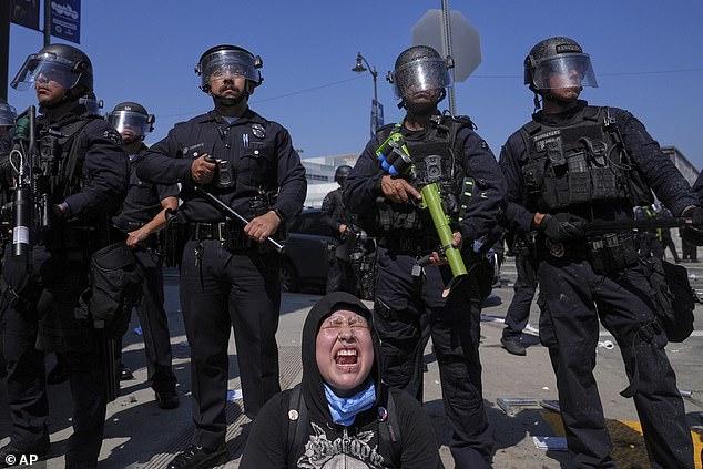 A woman screams as officers create a wall against the protesters