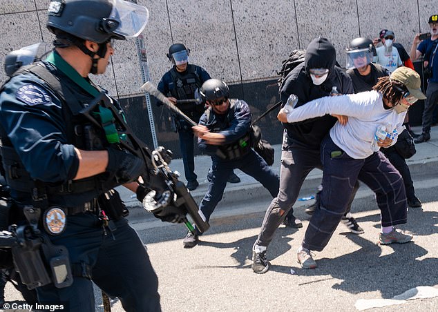 The National Guard, police and protesters stand off outside of a downtown jail in Los Angeles