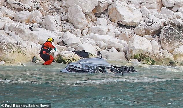 The silver vehicle fell into the water below the cliff on Friday