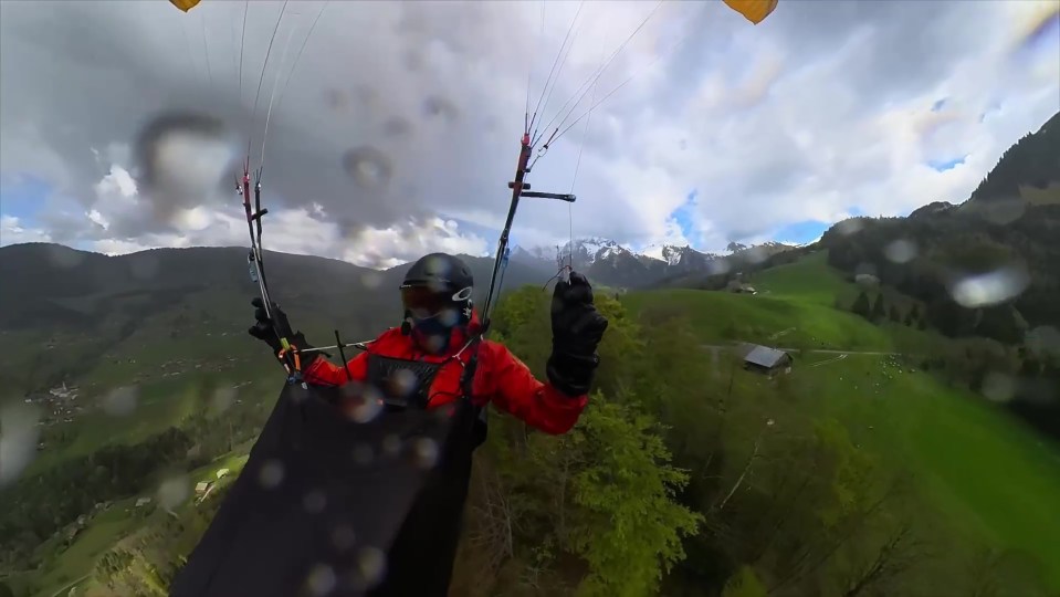 A paraglider falling through the air above the French Alps.